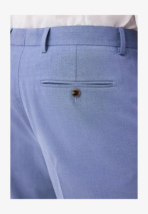 Lichtblauwe broek van een gestructureerde stof, met een enkele achterzak met een ronde bruine knoop en een getailleerde pasvorm.