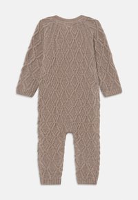Adīts beidzis jumpsuits ar teksturētu dimanta rakstu, garām piedurknēm un ribotu aproču. Mīksts materiāls ar brīvu piegriezumu.