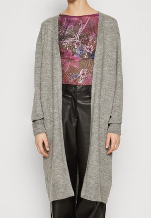 Grauer gestrickter Cardigan mit lockerer Passform und langen Ärmeln, mit gerippten Bündchen und offenem Design, getragen über einem gemusterten Oberteil.
