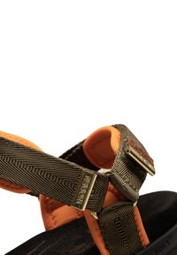 Ruskean kuviolliset nailonista tehdyt sandaalit oranssilla pehmusteella, joissa on kullatut yksityiskohdat ja musta texturoitu pohja.