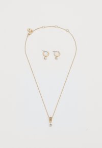 Set di gioielli in tono oro composto da una delicata collana con catena, pendente rettangolare e pietra preziosa trasparente, abbinata a orecchini a cerchio coordinati.