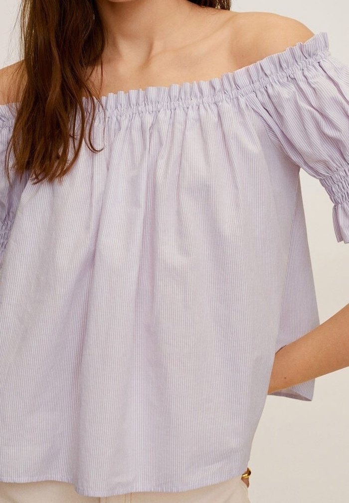 Top off-the-shoulder di un leggero viola con scollo arricciato, caratterizzato da righe bianche verticali e una vestibilità ampia e fluida. Tessuto di cotone.