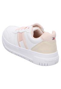 Baskets blanches avec des accents roses, présentant une tige synthétique lisse, un bout rond et un col rembourré. Semelle en caoutchouc blanche avec une adhérence texturée.