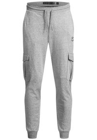 Jogging cargo en coton gris avec poches latérales, taille élastique et cordon de serrage. Présente un logo sur la cuisse et des bas de jambe fuselés.