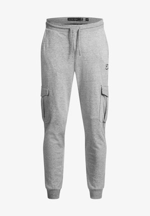 Sive pamučne cargo trenirke s bočnim džepovima, elastičnim pojasom i vezicom. Imaju logo na gornjem dijelu noge i sužene manžete na gležnjevima.