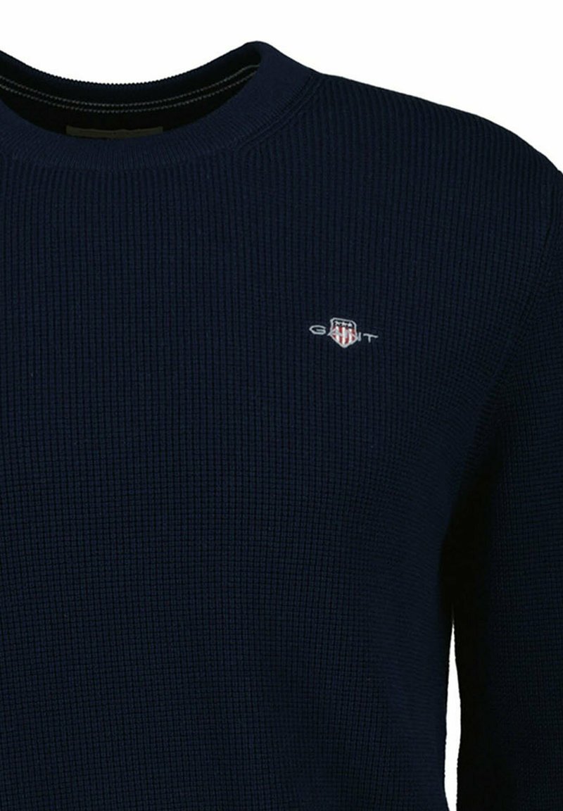 Maglione in maglia blu navy con collo rotondo, tessuto strutturato e piccolo logo ricamato sul petto. Design a vestibilità normale.