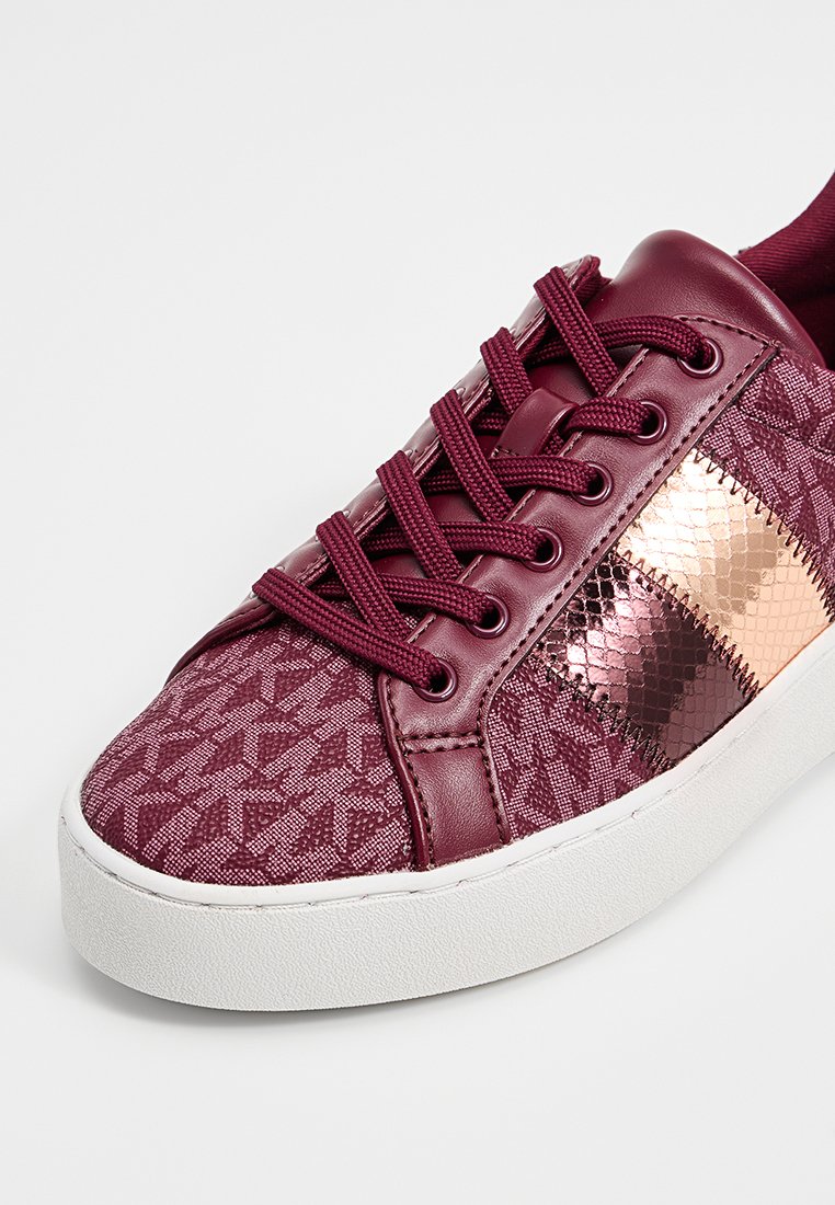 Baskets bordeaux avec un dessus en tissu texturé, des accents en cuir lisse, des détails métalliques en or rose et une semelle en caoutchouc blanc.