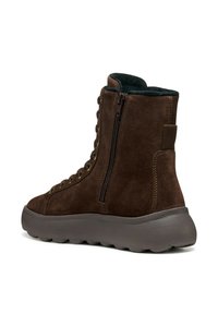 Stivale alla caviglia in suede marrone con superficie testurizzata, lacci frontali, zip laterale e suola spessa e imbottita. Presenta occhielli in metallo e cuciture accentuate.