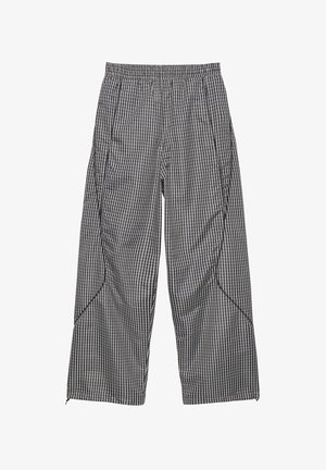 Volné černobíle kostkované kalhoty s elastickým pasem a zakřivenými švy na nohavicích.