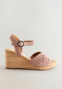 Sandaalit, joissa on pinkkiä oljenkaltaista materiaalia; niissä on korkinvärinen alustan korko, säädettävä nilkkahihna ja pyöristetty varvastyylinen muoto.