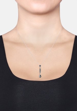 Silberne Anhängerhalskette mit fünf dunklen Edelsteinen, die an einem Tropfen am Ende endet. Die Kette ist dünn und zart und ergänzt das Design.