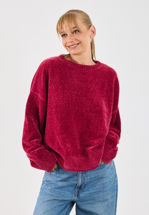Maglione a maglia bordeaux con scollatura a girocollo, spalle scese e vestibilità ampia. Presenta polsini e orlo a costine, tessuto testurizzato.