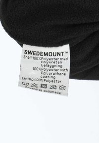 Zwarte fleece-stof met een label waarop "SWEDEMOUNT" staat, met details over materialen: buitenlaag, voering en onderhoudsinstructies. De labels zijn wit met zwarte tekst.
