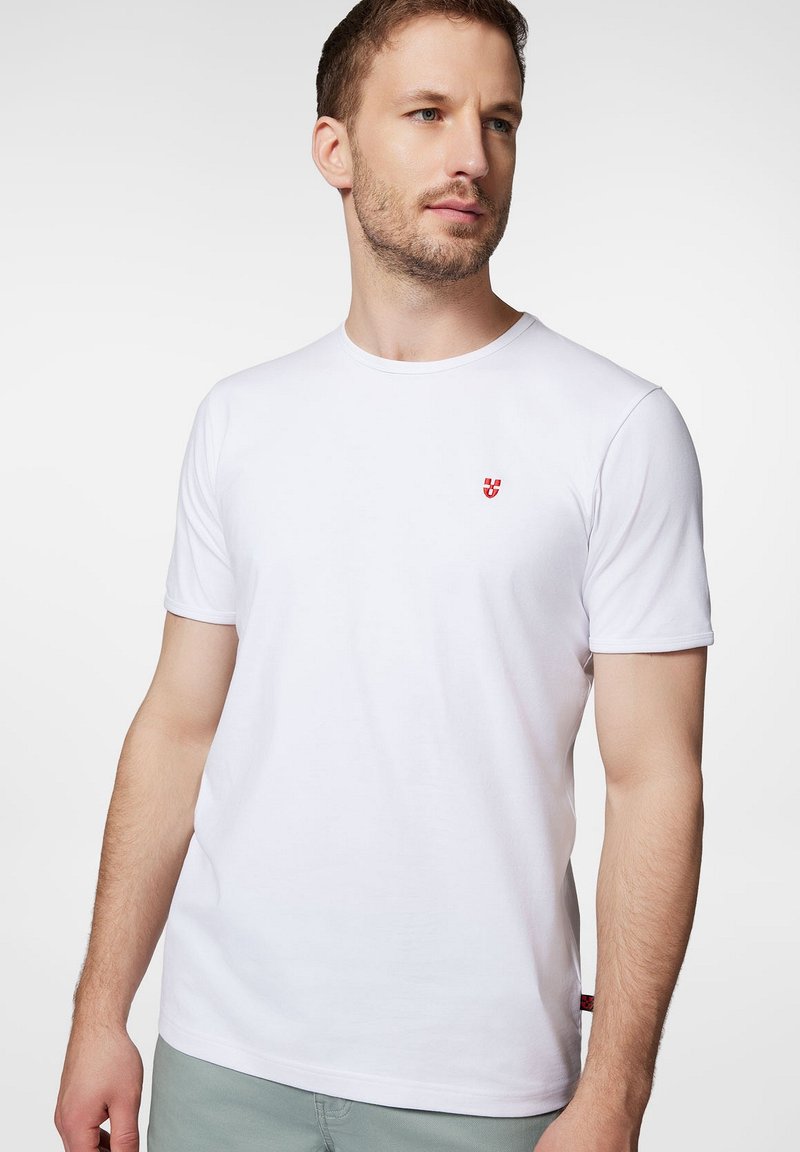 Biała koszulka z krótkim rękawem, wykonana z bawełny, okrągły dekolt, z małym czerwonym logo na lewej piersi, gładka faktura, standardowy krój.