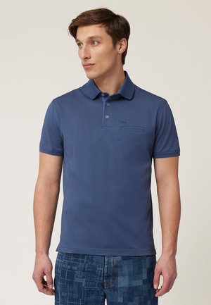 Blauwe polo met een kraag en twee knopen. Korte mouwen, gemaakt van een gladde stof. Voorzien van een zakdetail met stiksels.
