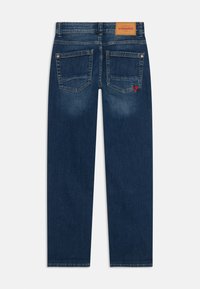 Jeans de mezclilla azul oscuro con corte recto, que presentan dos bolsillos traseros, una etiqueta de cuero con "VINGINO" y un acento bordado en rojo con una "V".