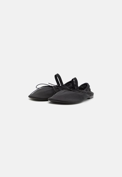Svarta slip-on-skor med spetsiga tår, tillverkade av slät tyg, med snörning framtill och dragflikar bak för enkel påläggning och komfort.