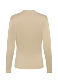 Långärmad beige topp med en slät textur, smal passform och en liten slits på baksidan vid halsringningen. Inga synliga mönster eller dekorationer.