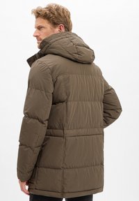 Brązowa puchowa kurtka z kapturem, z pikowanymi panelami i gładką fakturą. Krój jest luźny, a zdobienia minimalistyczne.
