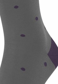 Calza grigia con una texture liscia, accentuata da pois viola e un'area del tallone di un viola più scuro.