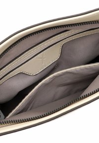 Interno marrone di una borsa con due scomparti, dotata di una cerniera liscia beige e di una tasca in pelle beige con dettagli del logo.
