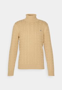 Beige Kabelstrick-Turtleneck-Pullover mit gerippten Bündchen und Saum. Mit dezentem Logo-Akzent auf der Brust. Weicher Stoff, taillierte Passform.