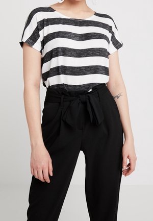 Czarnobiała koszulka w paski o luźnym kroju i krótkich rękawach, zestawiona z czarnymi spodniami z wysokim stanem, z wiązanym paskiem w talii.