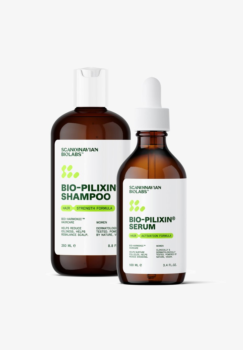 Brune glasflasker med hvide kapsler. Shampoen (250 ml) har en grøn etiket, mens serumet (100 ml) har en pipette og lignende branding.