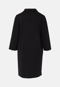 Schwarzer, knielanger Mantel mit dreiviertellangen Ärmeln und einem schlichten Kragen, von hinten vor einem einfarbigen hellen Hintergrund gezeigt.