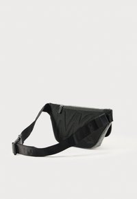 Black mesh crossbody bag with textured pattern, zip closure, adjustable strap, and gray lining. Compact design suitable for casual use.