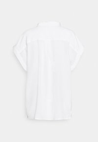 Weißes Leinenhemd mit kurzen Ärmeln, das einen lockeren Schnitt, einen Kragen und eine Rückenpasse aufweist. Glatte Textur und minimalistisches Design.