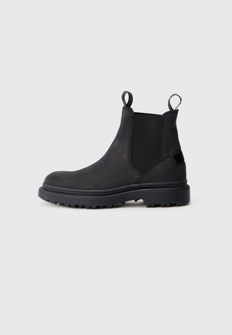 Bottines Chelsea noires en cuir, avec des panneaux latéraux élastiques, des languettes de tirage, des semelles en caoutchouc texturé et descoutures renforcées.