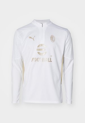 Jersey de fútbol de manga larga blanca con cuello de media cremallera, detalles en dorado, un patrón texturizado y un logo bordado en el pecho.