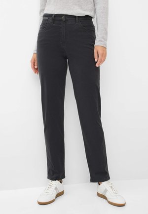 Schwarze Baumwollhose mit fünf Taschen, Knopfverschluss und geraden Beinen, kombiniert mit weißen Sneakers mit einem hellgrauen Akzent.
