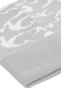 Scialle grigio lavorato a maglia con un motivo di uccelli bianchi, con una texture a coste alle estremità e un aspetto morbido e accogliente.