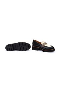 Mocasines de cuero negro y crema con suela chunky, que presentan una correa decorativa y detalle de hebilla, costura texturizada y un acabado suave.