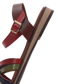 Sandalo in pelle multicolore con cinturini rossi, verdi e blu, dotato di una base marrone e una suola robusta a righe marroni e nere. Con dettaglio di fibbia.