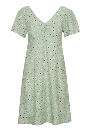 Groene jurk van zacht materiaal met een V-hals, korte mouwen en een bloemenprint in wit en zwart. Beschikt over plooien bij de buste.