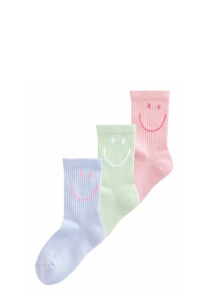 Drei gerippte Sneakersocken in Pastellblau, Grün und Rosa, jeweils mit einem großen lächelnden Gesicht nahe dem oberen Rand.
