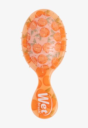 Brosse Wet Brush orange pour cheveux, avec des poils arrondis et un motif de petits fruits orange avec des feuilles vertes sur un coussinet blanc et une poignée.