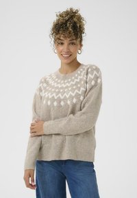 Pulover tricotat bej, cu un model geometric alb la umeri, guler rotund, umeri căzuți și manșete și tiv cu model în relief.