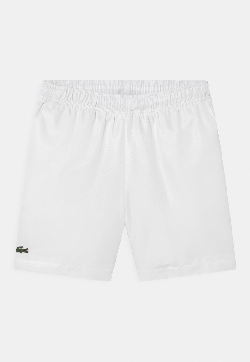 Short blanc à taille élastique avec un petit logo crocodile vert en bas de la jambe gauche, présenté sur un fond uni.