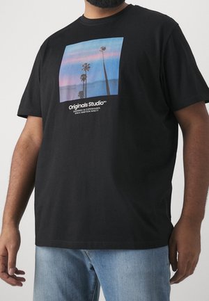 Czarny bawełniany t-shirt z prostokątną grafiką przedstawiającą palmy na tle niebiesko-różowego zachodu słońca oraz napisem "Originals Studio" poniżej.