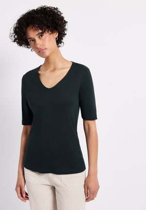 Haut vert foncé à manches courtes avec un décolleté en V. Fabriqué en tissu doux et lisse avec une coupe ajustée. Accentué par un ourlet subtil.