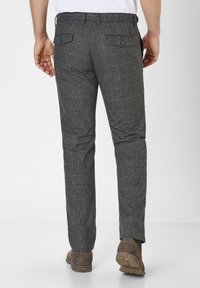 Pantalon à carreaux gris en tissu tissé, avec deux poches arrière à boutons et une coupe droite.