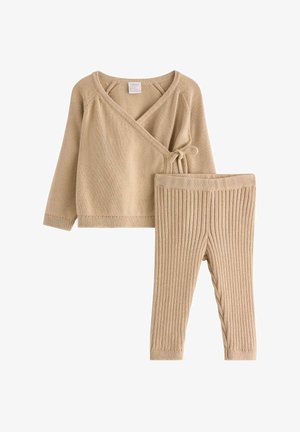 Beige strikket wrap top med knytelukning, parret med ribbede leggings i matchende farve. Blød tekstur, lange ærmer og tætsiddende design.