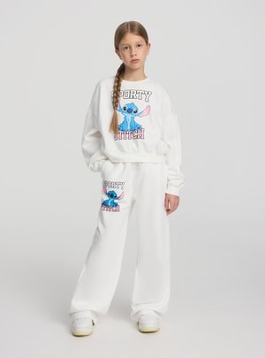 Completo intimo bianco composto da una felpa con grafica cartoon di Stitch e la scritta "SPORTY STITCH", abbinata a pantaloni coordinati.
