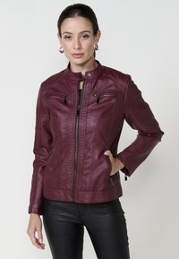 Veste de moto en cuir bordeaux avec un col montant, des poches zippées et des épaules texturées. Dotée d'un design ajusté.