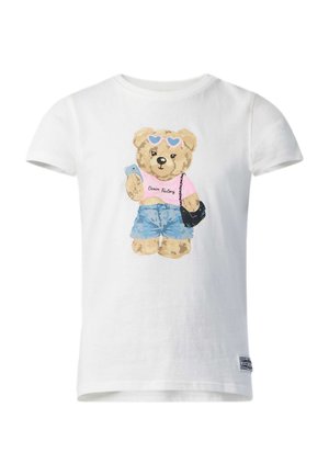 T-shirt blanc avec un ours en peluche portant des lunettes de soleil en forme de cœur, un haut rose, un short en jean et un sac noir à bandoulière.