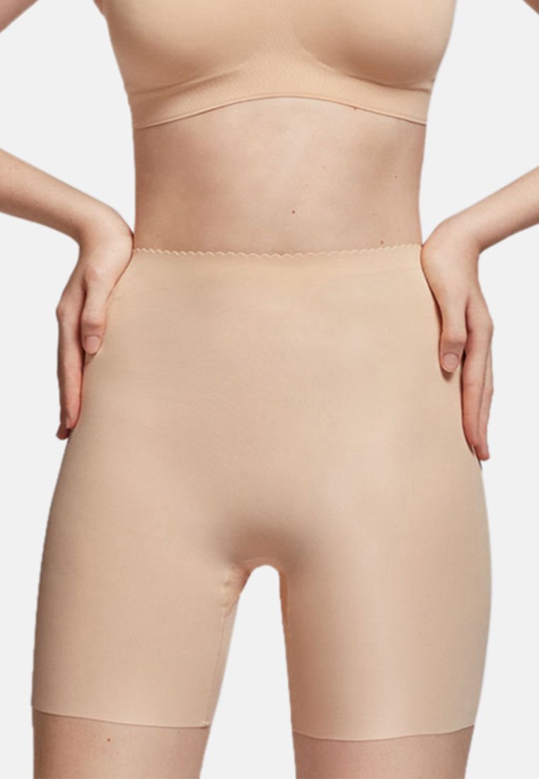 Beige high-waisted shapewear shorts made of smooth, stretchy material. Features a scalloped waistband and knee-length design.